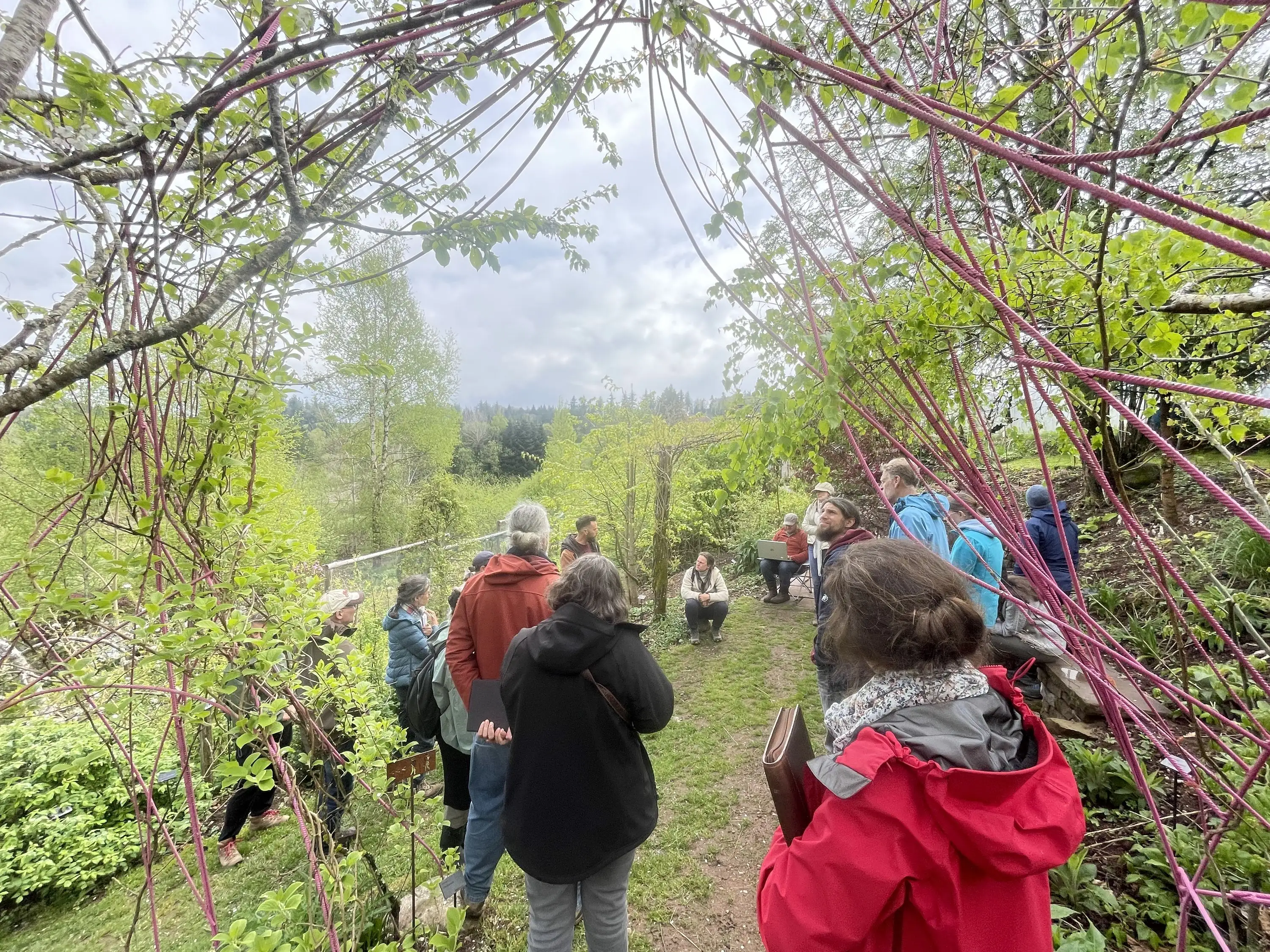 Le groupe d'étudiant·es sous une arche de branches tressées du jardin