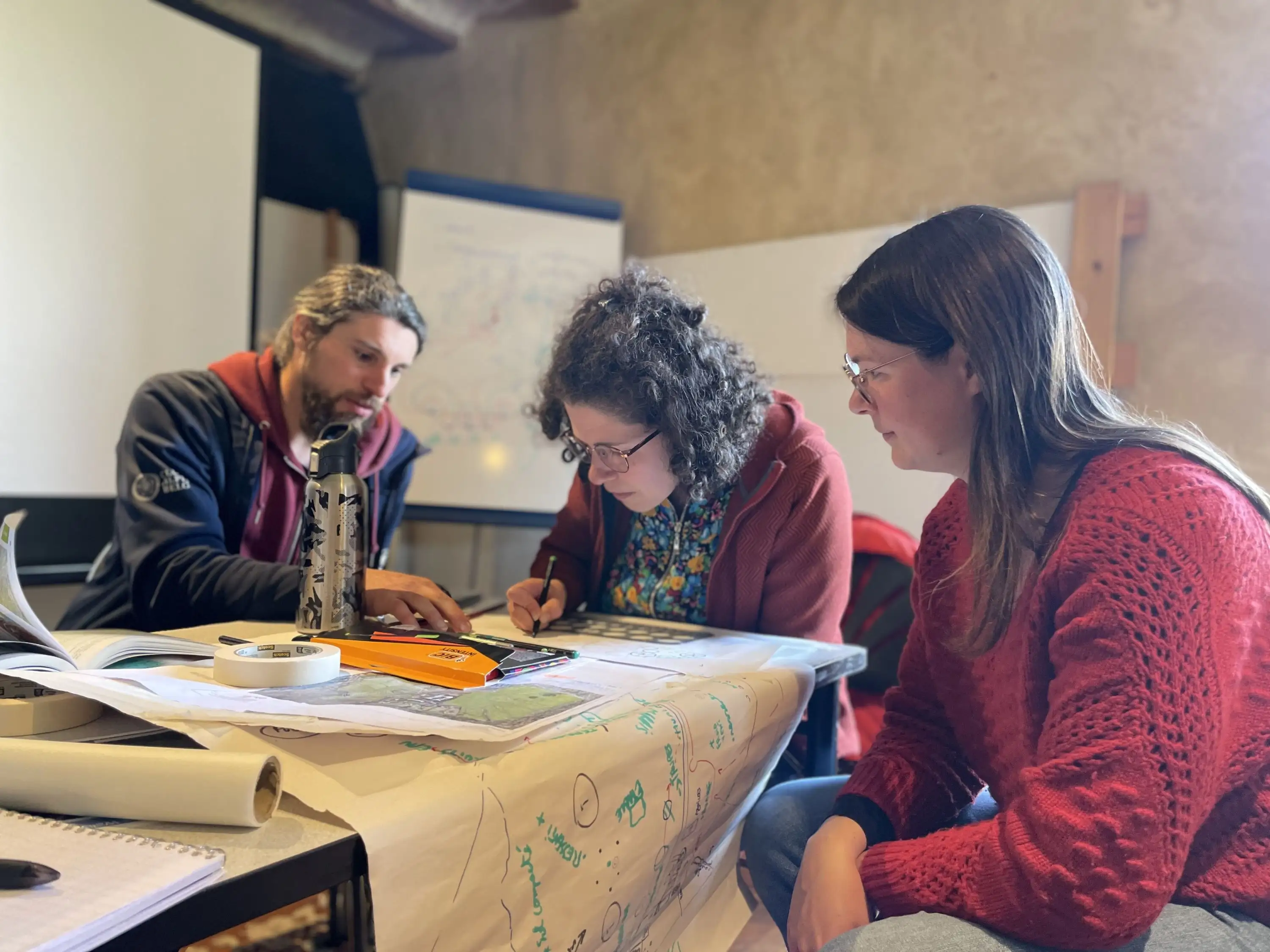 Étudiant·es du cursus en pleine session de conception, plans et cartes à l'appui